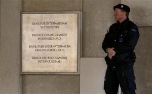 A member of a private security company stands beside a sign in front of the Bank For International Settlements (BIS) in Basel November 8, 2010. REUTERS/Arnd Wiegmann